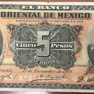 Może przedstawiać: Antyczny banknot pięciopesosowy z El Banco Oriental de Mexico, datowany na 23 listopada 1910 roku. Banknot przedstawia portret mężczyzny po lewej stronie, cyfrę 5 pośrodku i budynek po prawej stronie. Banknot jest w odcieniach brązu, brzoskwini i zieleni.