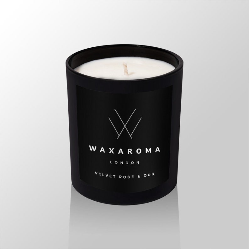 May include: Black candle jar with a white wax top and a white label that says "WAXAROMA LONDON VELVET ROSE & OUD".