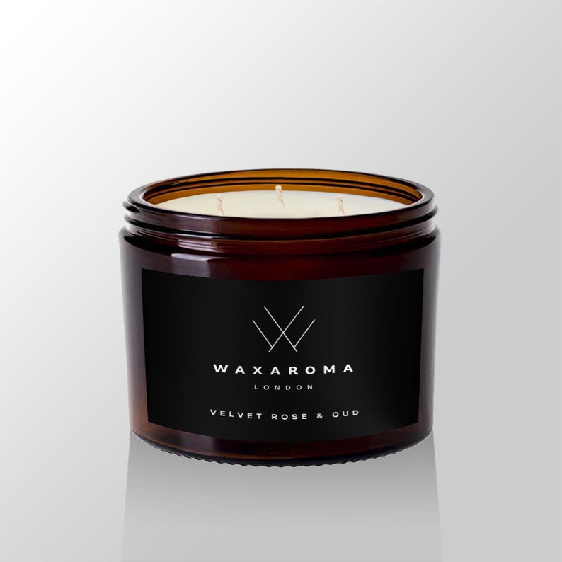 May include: A brown glass candle jar with a black label. The label has a white logo and the text "WAXAROMA LONDON VELVET ROSE & OUD".