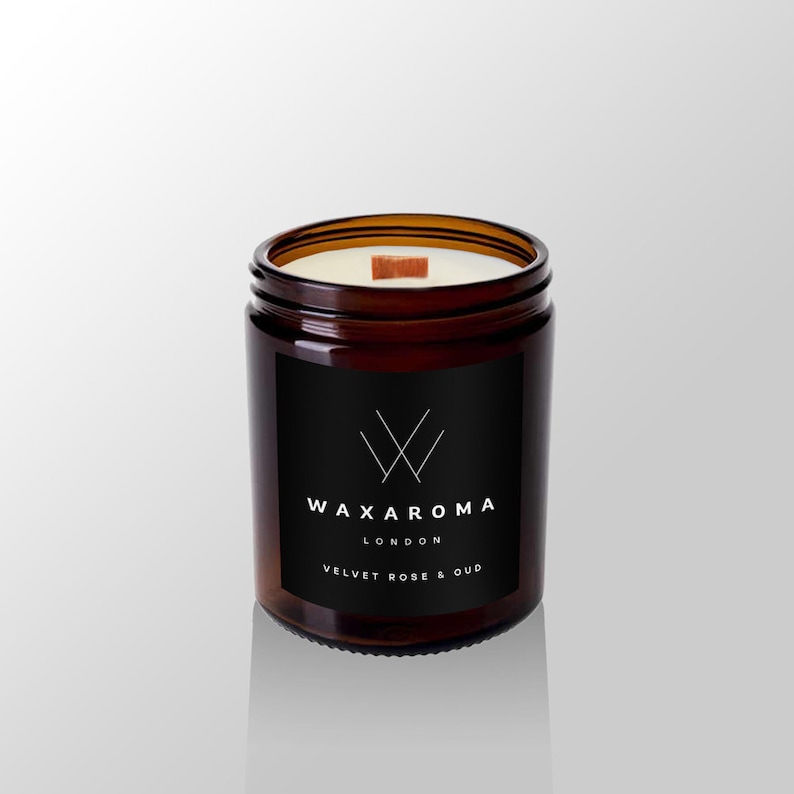 May include: A brown glass candle jar with a black label. The label has a white logo and the text "WAXAROMA LONDON VELVET ROSE & OUD".