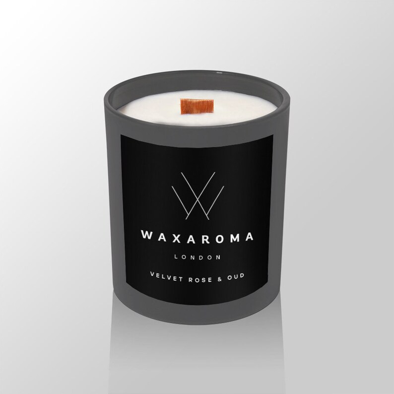 May include: A gray candle jar with a black label that reads "WAXAROMA LONDON VELVET ROSE & OUD". The candle has a wooden wick and a white wax top.