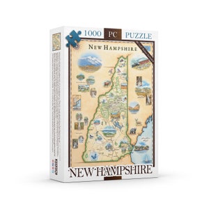 May include: A 1000 piece jigsaw puzzle featuring a map of New Hampshire with illustrations of landmarks and wildlife. The puzzle box has the text "New Hampshire" and "1000 PC Puzzle" printed on it.