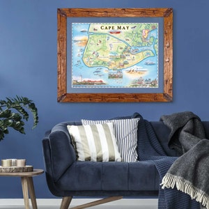 May include: A framed map of Cape May, New Jersey, with a rustic wooden frame. The map is illustrated with colorful details, including a lighthouse, beach, and houses. The title "Cape May" is printed in red at the top of the map.