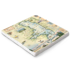 Puede incluir: Posavasos cuadrado de cerámica con un mapa detallado del lago Flathead, Montana. El mapa incluye ilustraciones de flora y fauna locales, con un contorno azul del lago. El posavasos tiene un borde blanco.