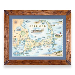 Op de afbeelding: Een ingelijste kaart van Cape Cod met illustraties van lokale dieren, vuurtorens en schepen. De kaart is geplaatst tegen een blauwe achtergrond en ingesloten in een rustieke, verweerde bruine houten lijst met donkere metalen hoekaccenten.