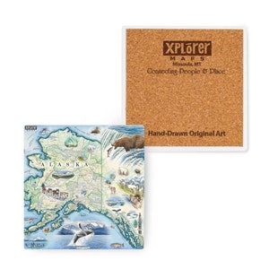 Puede incluir: Un posavasos de cerámica con un mapa dibujado a mano de Alaska con varios animales y puntos de referencia. El posavasos es blanco con un borde azul y el texto "XPLorer MAPS Missoula, MT Connecting People & Place" está impreso en marrón en la parte superior. El texto "Hand-Drawn Original Art" está impreso en marrón en la parte inferior.