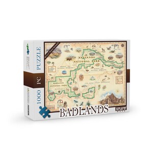 May include: A 1000 piece jigsaw puzzle featuring a map of Badlands National Park in South Dakota. The puzzle box is brown with a vintage style map design. The text on the box reads "Badlands National Park" and "Xplorer Maps".