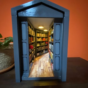 Mirror in the back create depth inside the cozy library scene.