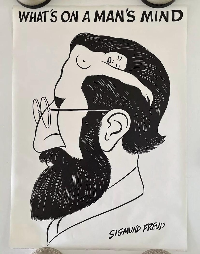 May include: Black and white poster featuring a stylized illustration of Sigmund Freud's profile. The image includes the text "WHAT'S ON A MAN'S MIND" at the top and "SIGMUND FREUD" at the bottom. A nude figure is integrated into the profile.