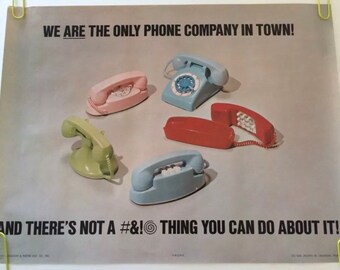 Op de afbeelding: Een vintage poster die reclame maakt voor een telefoonbedrijf met de slogan "We zijn het enige telefoonbedrijf in de stad! En daar kun je niets aan doen!" De poster toont vijf verschillende gekleurde draaischijftelefoons.