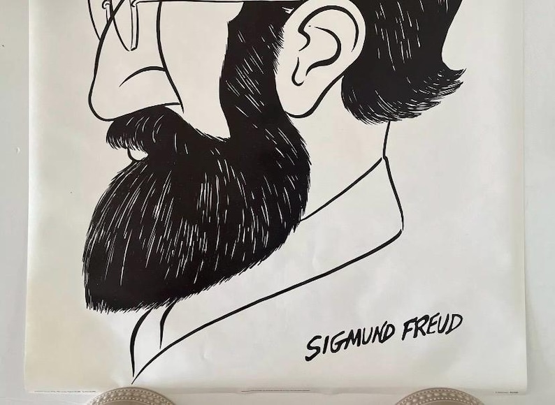 May include: Black and white illustration of Sigmund Freud, featuring a detailed depiction of his profile. The image highlights his distinctive beard, glasses, and the text "SIGMUND FREUD" at the bottom, creating a striking visual.