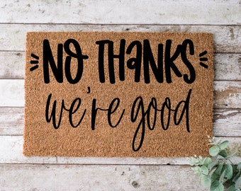 May include: A brown coir doormat with the text "NO THANKS, we're good" in black lettering.