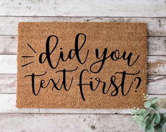 May include: A brown coir doormat with the text "did you text first?" in black cursive lettering.
