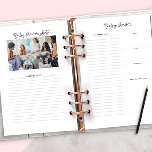 Op de afbeelding: Een witte planner met een ros&eacute;gouden ringband. De linkerpagina heeft de tekst "Baby shower photo" en een foto van een groep mensen op een babyshower. De rechterpagina heeft de tekst "Baby shower" en een lijst voor boodschappen, datum, plaats, organisator en babyshowerthema.