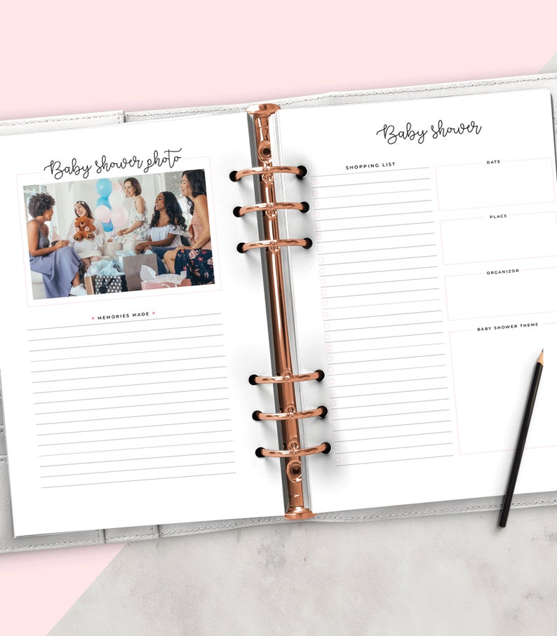 Op de afbeelding: Een witte planner met een ros&eacute;gouden ringband. De linkerpagina heeft de tekst "Baby shower photo" en een foto van een groep mensen op een babyshower. De rechterpagina heeft de tekst "Baby shower" en een lijst voor boodschappen, datum, plaats, organisator en babyshowerthema.
