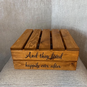 May include: A wooden crate with the words "And they lived happily ever after" engraved on the front. The crate is stained a dark brown color.