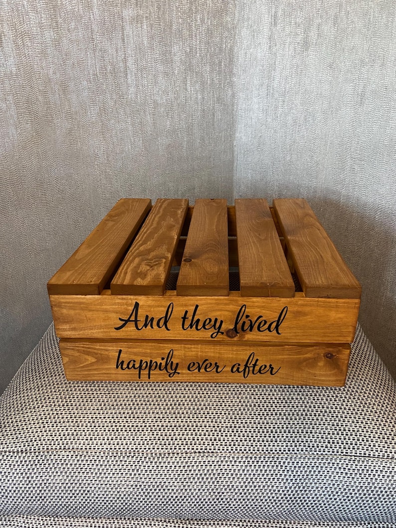 May include: A wooden crate with the words "And they lived happily ever after" engraved on the front. The crate is stained a dark brown color.