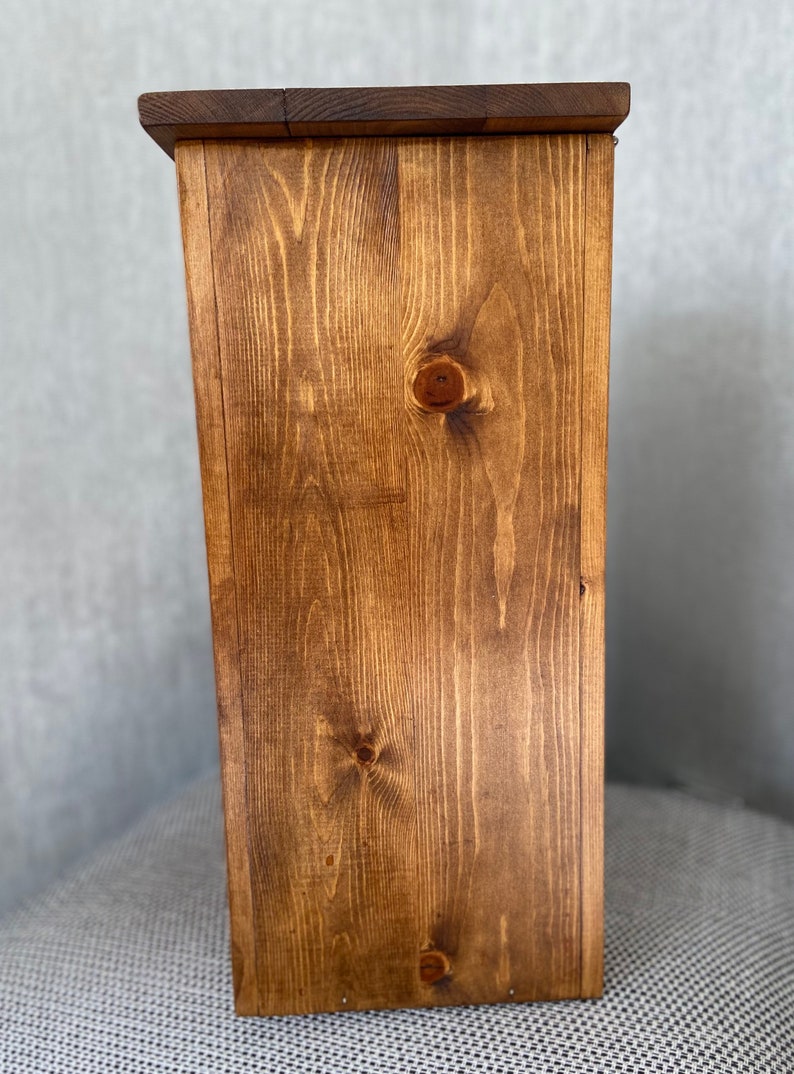 May include: A wooden box with a dark brown stain. The box is made of solid wood with a visible grain pattern.