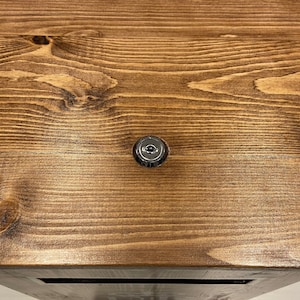 May include: A close-up of a wooden surface with a silver keyhole.