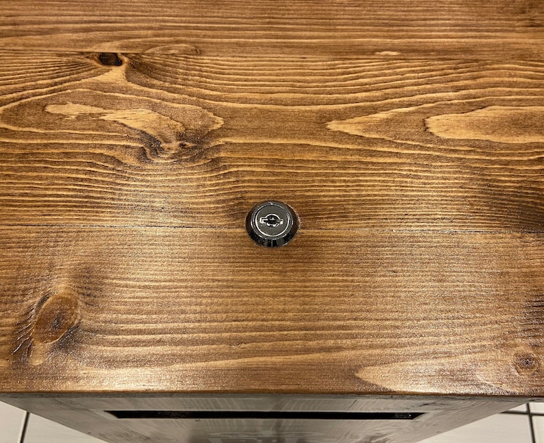 May include: A close-up of a wooden surface with a silver keyhole.