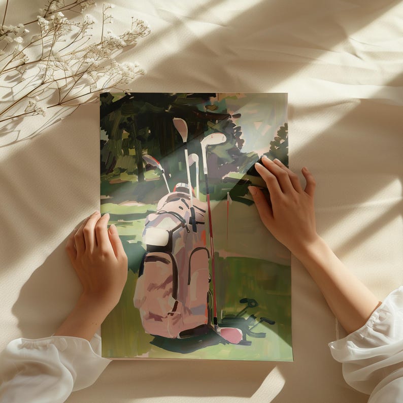 May include: An artistic print depicting a golf bag and clubs on a green golf course. The golf bag is a light pink colour, and the clubs are white and silver. The background features trees and sunlight.