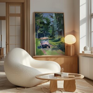 May include: An interior scene featuring a large, framed painting of a golf cart on a green path through a forest. A white, rounded armchair and a wooden coffee table with a glass top are in the foreground. A wooden lamp with a round, white shade sits on a wooden cabinet.