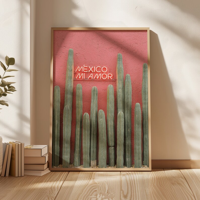 May include: A framed print with a pink background and a row of tall green cacti. The print features the text "M&Eacute;XICO MI AMOR" in neon pink.