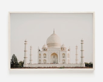 May include: A framed print of the Taj Mahal, a white marble mausoleum in India. The image shows the symmetrical structure with its central dome, minarets, and reflecting pool. The print is set against a neutral background.
