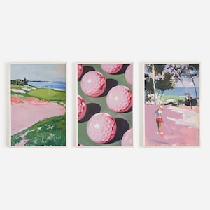 May include: A set of three framed art prints with golf themes. One print shows a golf course with a pink sand trap and green grass. Another features pink golf balls on a green background. The third shows a golfer on a course.