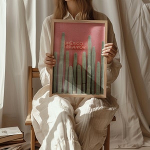 May include: A framed print with a pink background and a row of green cacti. The print has the text "Mexico Mi Amor" in white.
