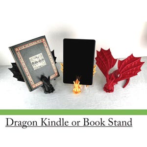 May include: Dragon-themed Kindle or book stands in black, gold, and red. One stand holds a book, another a tablet, and a third is a dragon wing design. The stands are designed to hold books or tablets.