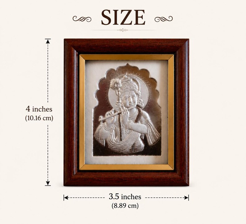 May include: Silver-coloured framed artwork of a deity playing a flute. The frame is dark brown with a gold inner border. The artwork is 10.16 cm tall and 8.89 cm wide. The word "SIZE" is at the top.