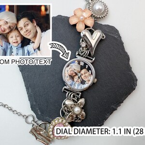 Puede incluir: Reloj de pulsera plateado con un dial de foto personalizado. La esfera del reloj tiene 28 mm de di&aacute;metro y muestra una foto familiar. La pulsera incluye dijes decorativos como un coraz&oacute;n, flores y una perla.
