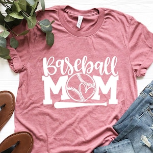 Op de afbeelding: Een roze T-shirt met de tekst "Baseball Mom" in wit, met een baseball- en hartgrafiek.