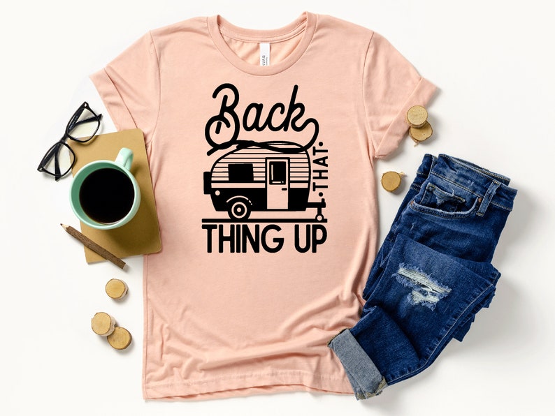 May include: A pink t-shirt with a black graphic of a camper van and the text "Back that thing up."