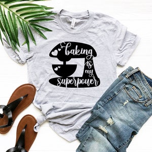 May include: A gray t-shirt with a black graphic of a stand mixer and the text "Baking is my superpower".