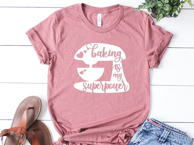 May include: A pink t-shirt with a white graphic of a stand mixer and the text "Baking is my superpower".