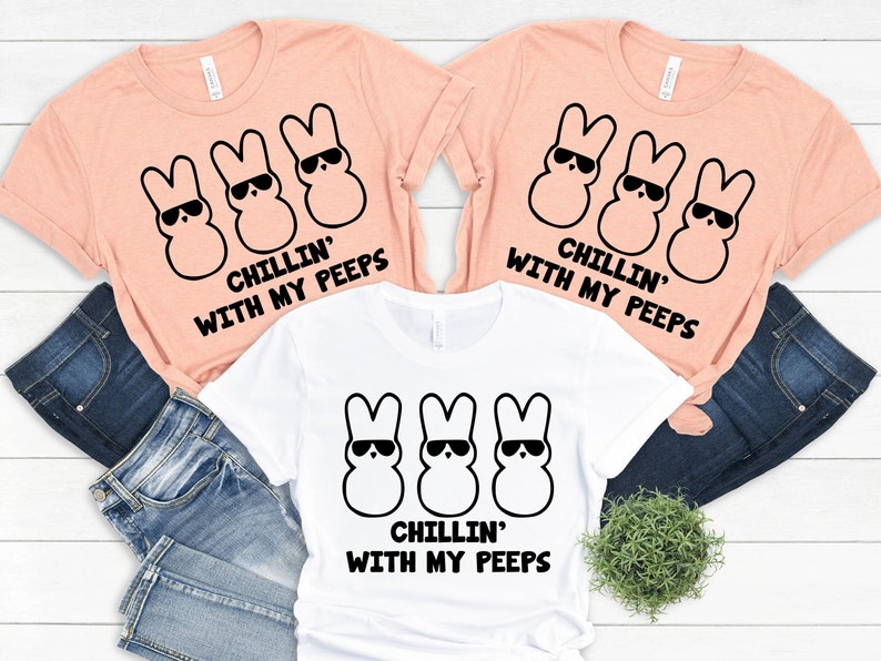 Peut inclure: Trois t-shirts de couleur p&ecirc;che avec un motif noir de trois Peeps de dessin anim&eacute; portant des lunettes de soleil et le texte "Chillin' with my peeps".