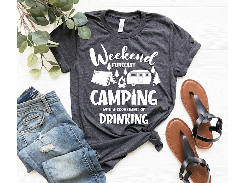 May include: A dark gray t-shirt with a white graphic that says "Weekend Forecast Camping with a good chance of Drinking". The graphic also includes a tent, a campfire, and a camper.