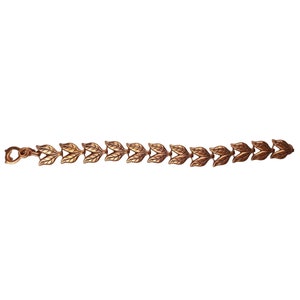 Op de afbeelding: Een gouden armband met een ketting van met elkaar verbonden bladeren.