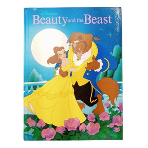 May include: A book cover featuring a colourful illustration of Belle and the Beast from Disney's Beauty and the Beast. The cover is blue with a yellow moon and stars. The title "Disney's Beauty and the Beast" is printed in pink and white.