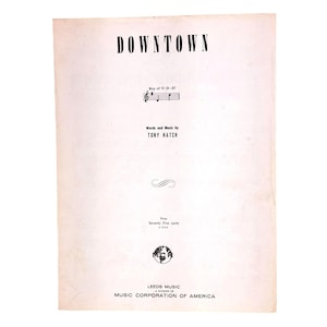 Peut inclure: Une tasse en céramique blanche avec une anse noire et le texte "But First, Coffee" en noir, en gras. La tasse est posée sur une surface blanche.