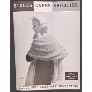 May include: A vintage instructional booklet titled STOLES CAPES SHORTIES featuring a black and white photograph of a person wearing a light-colored, open-work knit shawl. The cover includes the text BEAR BRAND and FLEISHER YARNS and VOL. 35-A.