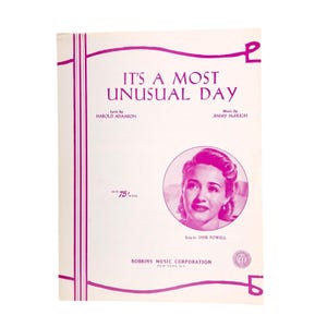 May include: Sheet music cover for "It's a Most Unusual Day" with a portrait of Jane Powell. The cover has a white background with magenta accents and text. The lyrics are by Harold Adamson, and the music is by Jimmy McHugh.