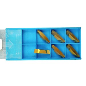 May include: A blue plastic storage case with six gold-colored metal inserts. The case has a clear plastic lid with an arrow pointing to the left.