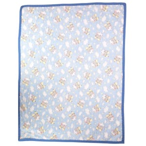 May include: A baby blanket featuring a light blue backdrop adorned with a repeating pattern of cartoon sheep, clouds, and stars. The blanket has a blue border and is likely made of soft fabric.