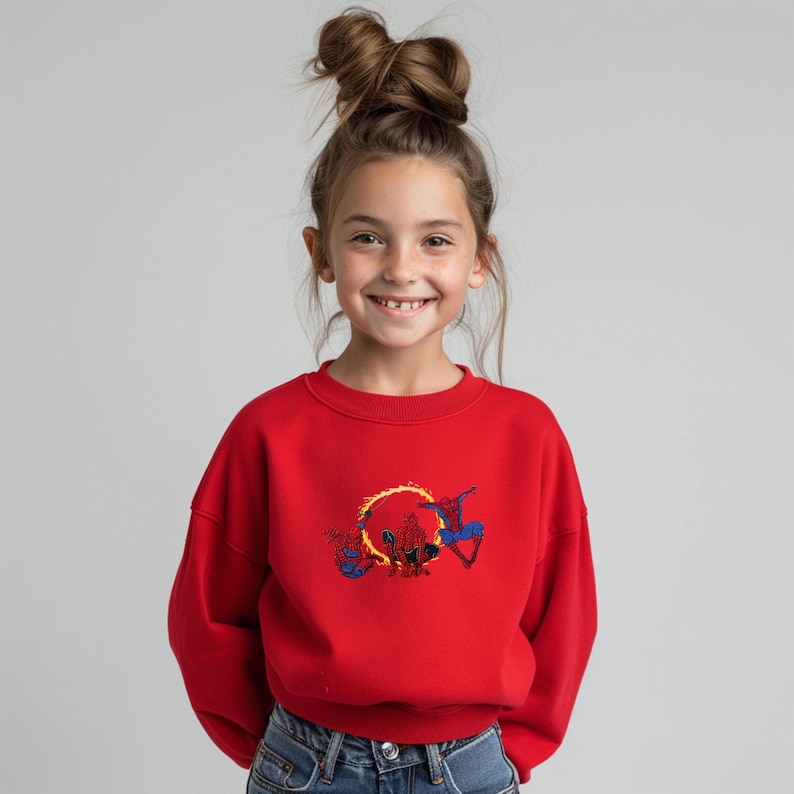 May include: A red crew neck sweatshirt with a Spider-Man design. The graphic depicts Spider-Man with a fiery ring. The sweatshirt is made of a soft material and is suitable for children.