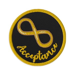 May include: A round black patch with a gold border and an infinity symbol in gold with a white outline. The word "Acceptance" is written in gold cursive below the symbol.