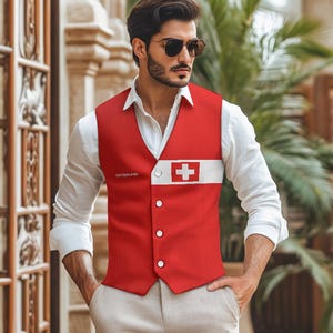 Puede incluir: Un chaleco rojo con una franja blanca y la bandera suiza. El chaleco tiene botones blancos y la palabra "SWITZERLAND" impresa en el lado izquierdo. Se usa sobre una camisa blanca y se combina con pantalones beige.