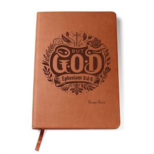May include: Brown leather journal with a floral design and the words "But God" and "Ephesians 2:4-5" engraved on the front. The text "Name Here" is also engraved on the front.